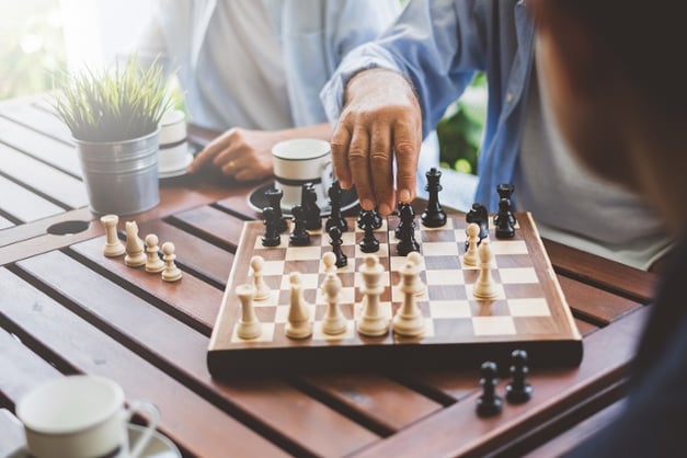 Playing chess with people in the background