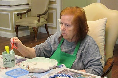 Senior woman painting plate