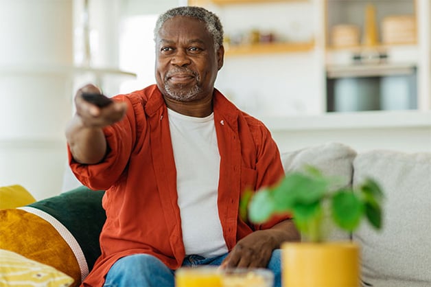 Senior man streaming tv shows from couch