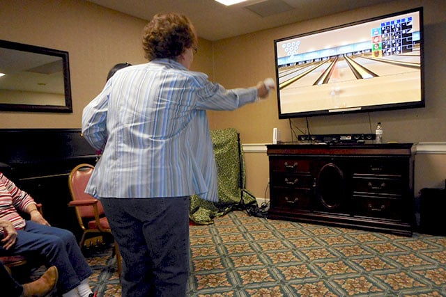 Happy elderly people spending time together at home, using gadgets